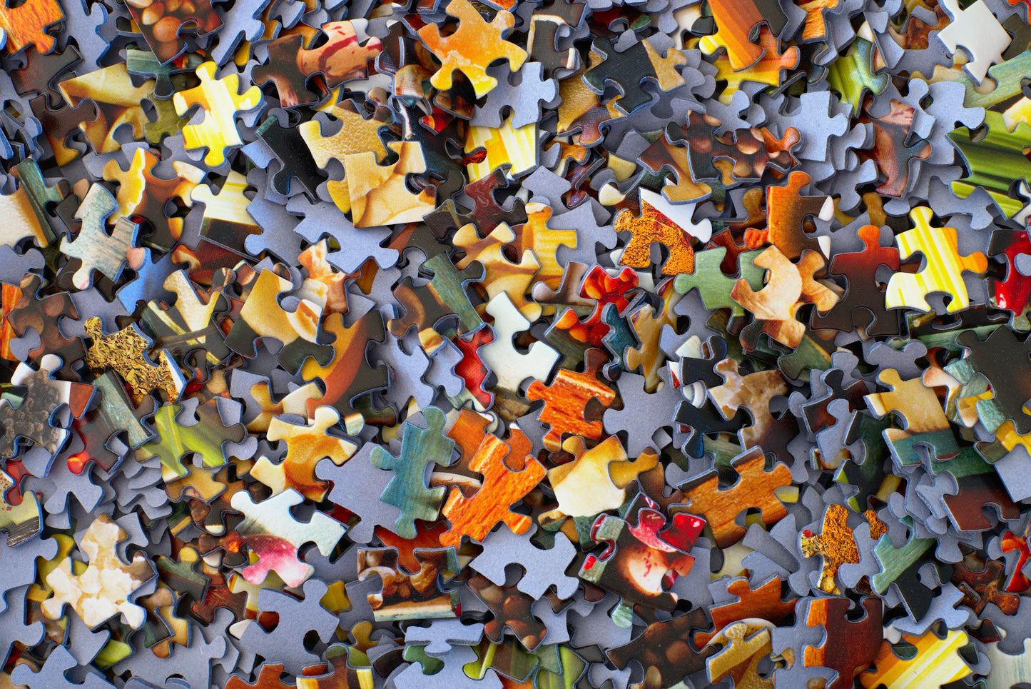 Stack of loose jigsaw puzzle pieces showing cardboard texture [unsplash:3y1zF4hIPCg]