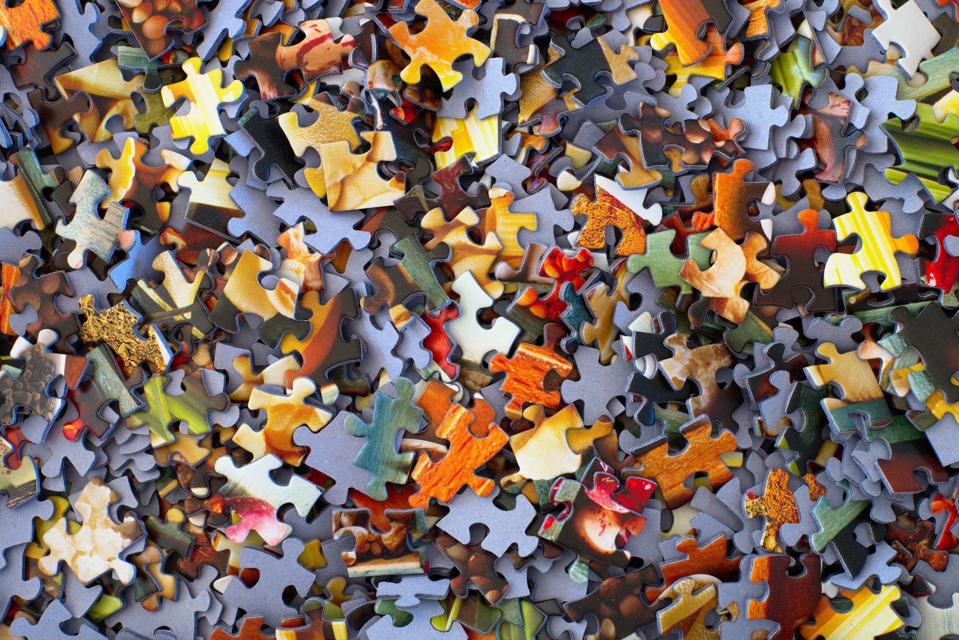 Stack of loose jigsaw puzzle pieces showing cardboard texture [unsplash:3y1zF4hIPCg]