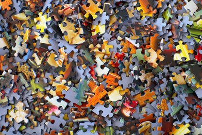 Stack of loose jigsaw puzzle pieces showing cardboard texture [unsplash:3y1zF4hIPCg]