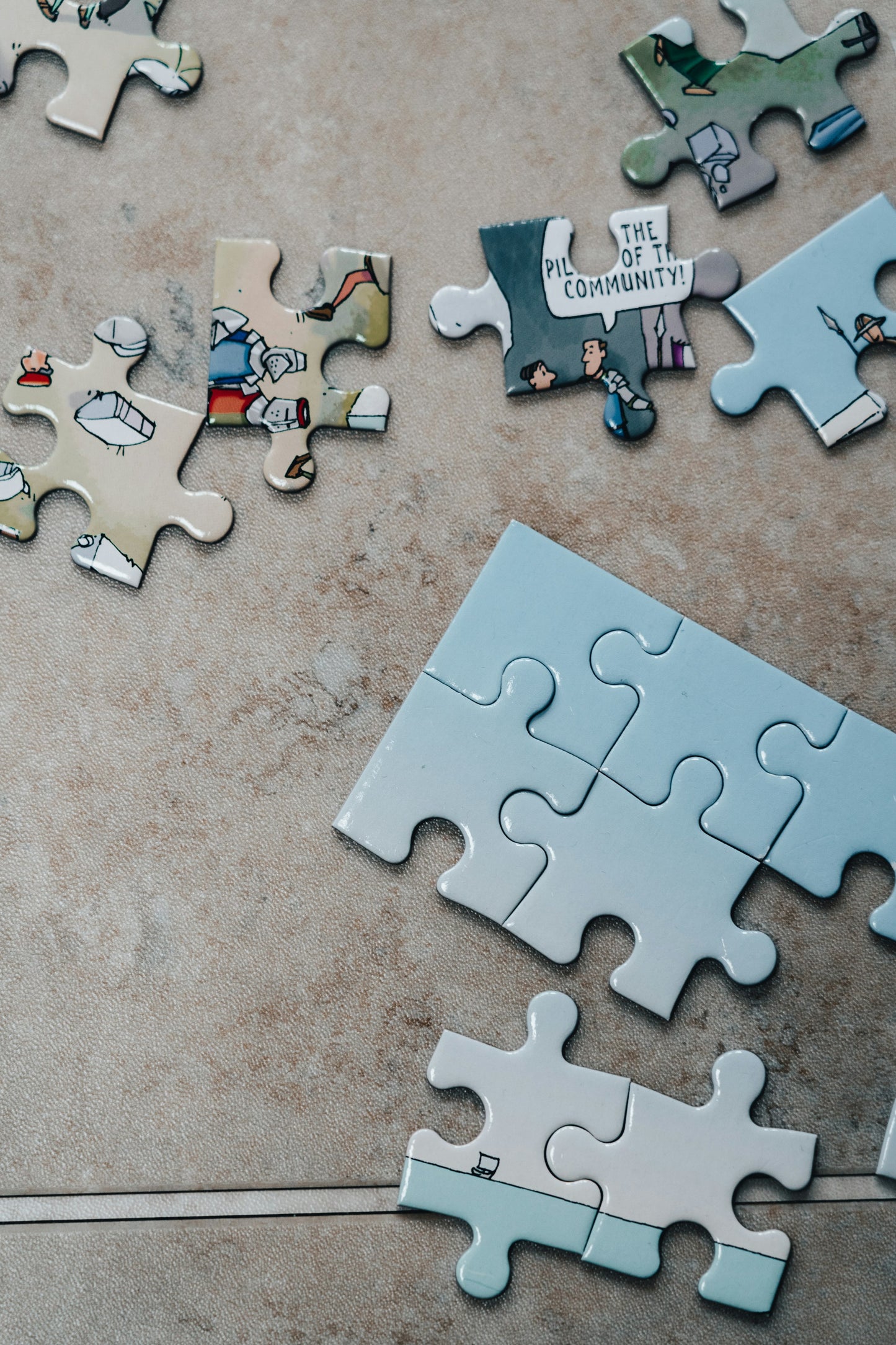 Assembled jigsaw puzzle pieces on a brown marble table [unsplash:SqjhKY9877M]